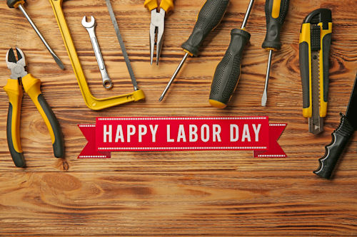 Happy Labor Day banner with tools on a wood bench.